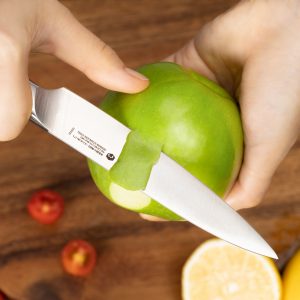 peeling a green apple by a utility knife