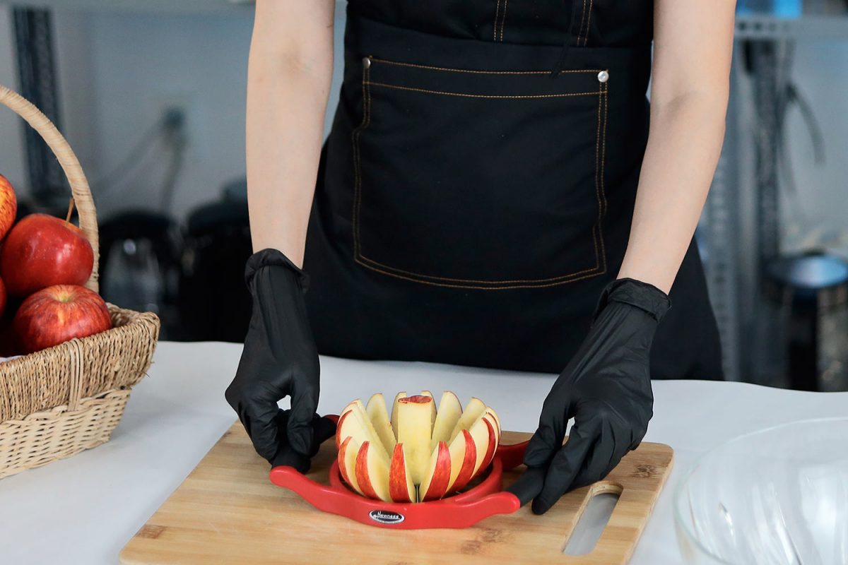 Person cutting an apple with a wedger